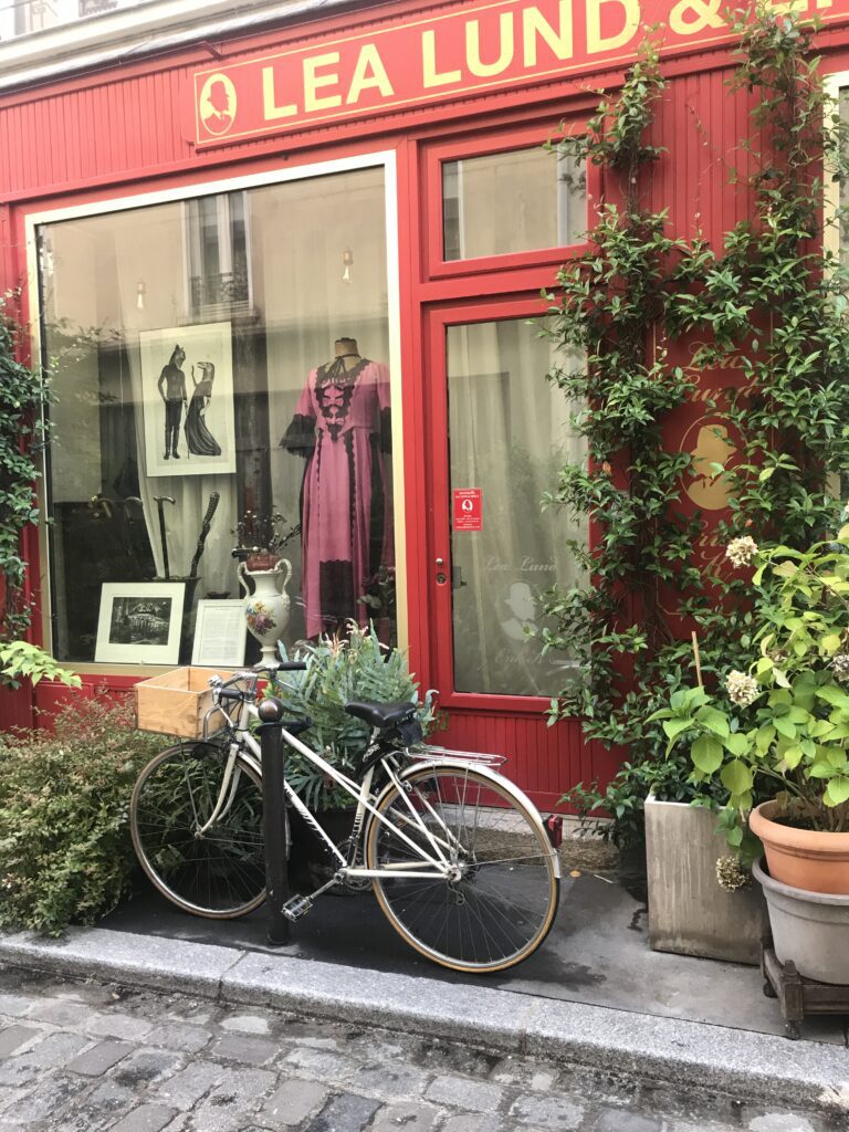 Charming Paris boutique with vintage bicycle and red facade in quiet neighborhood